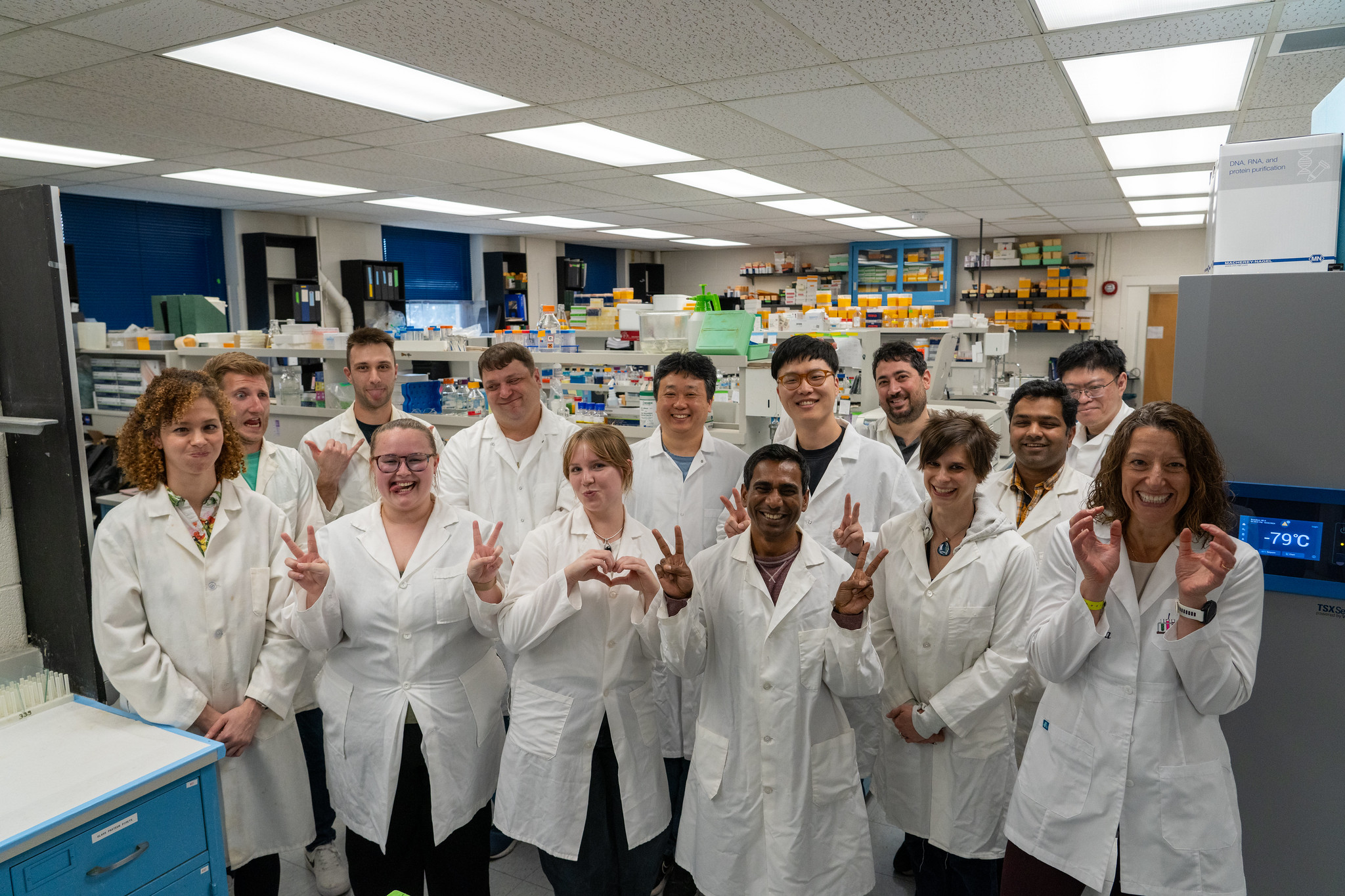 group of students with professor all wearing white lab coats